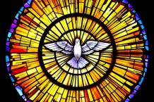 A religious stained glass window showing the symbol of the Holy Spirit
